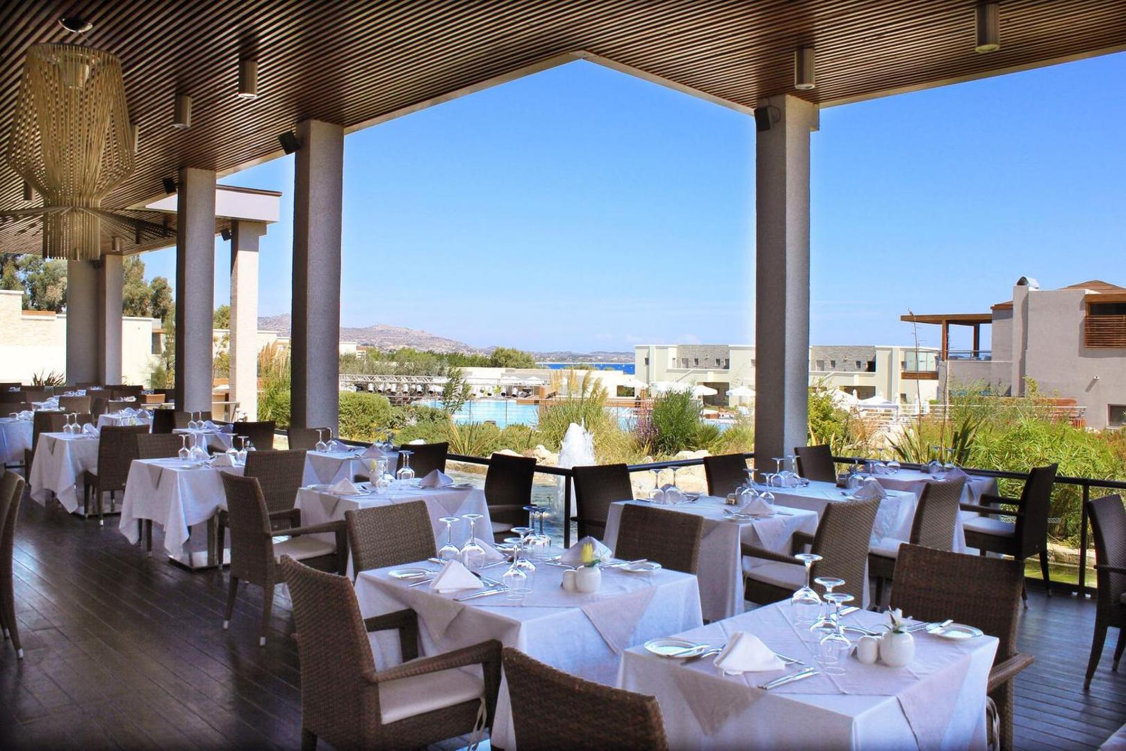 Sentido Port Royal Villas & Spa restorāna terase ar klātiem galdiem Rodas salā, skats uz baseinu un dārzu