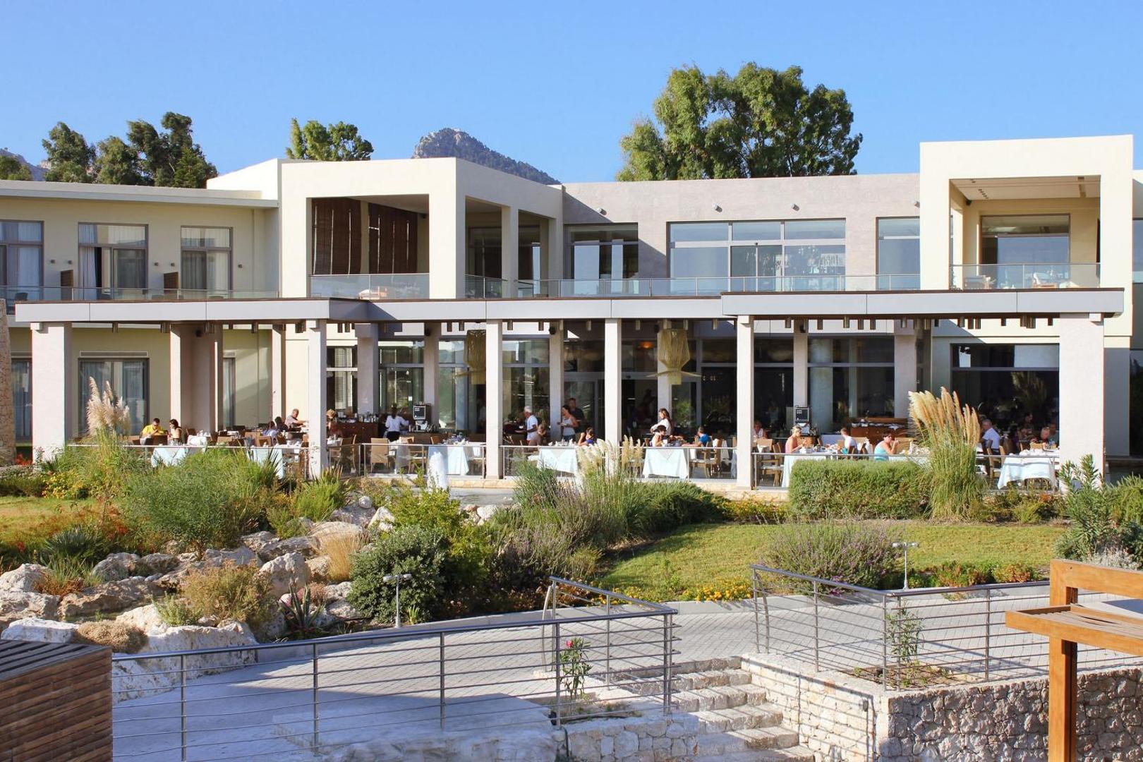 Sentido Port Royal Villas & Spa restorāna āra terase ar galdiņiem un viesiem pie dārza Rodas salā