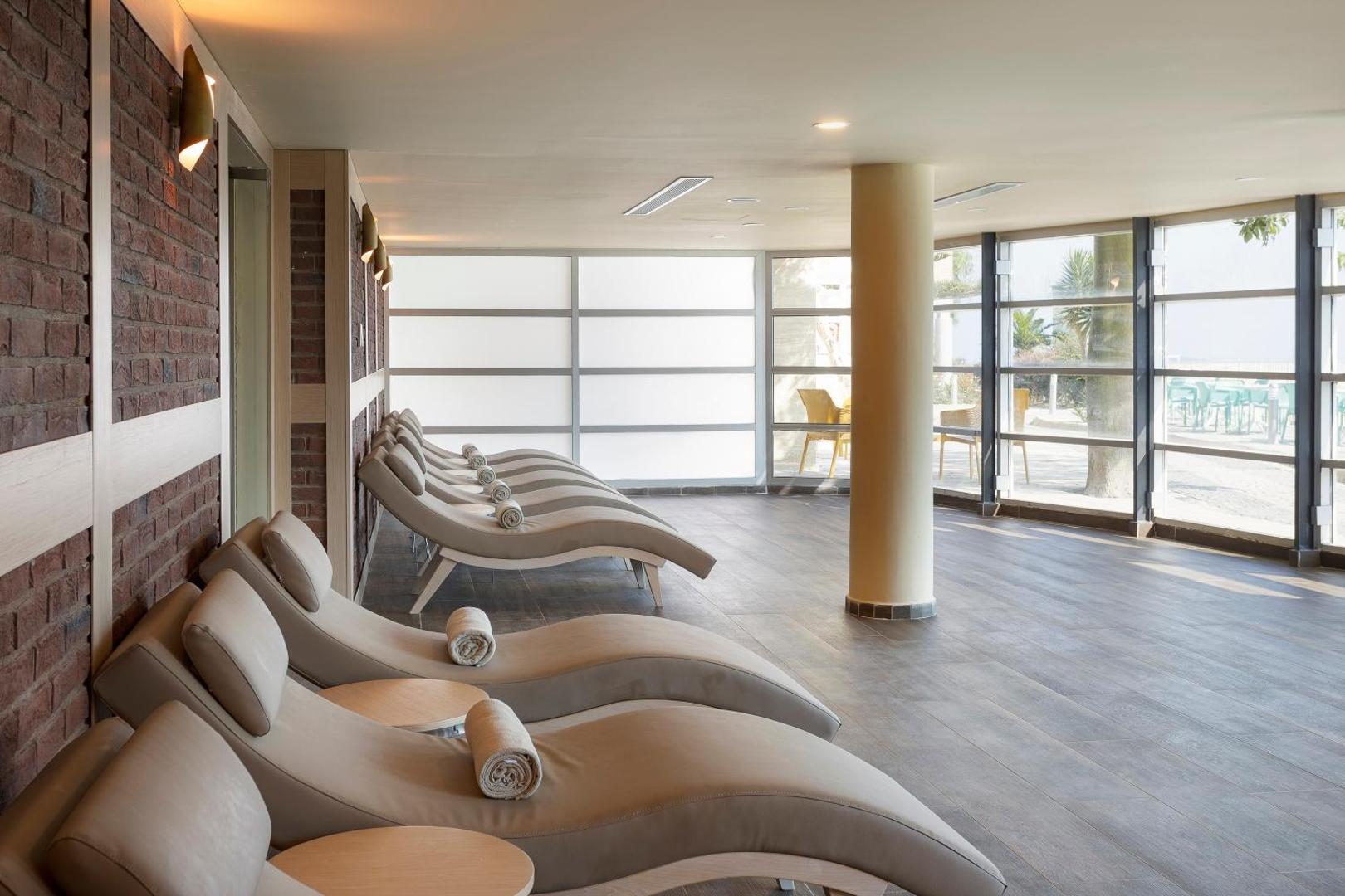 Duja Bodrum spa centra atpūtas zona ar ergonomiskiem zviļņiem un mīkstiem dvieļiem, skats caur panorāmas logiem uz kūrorta teritoriju