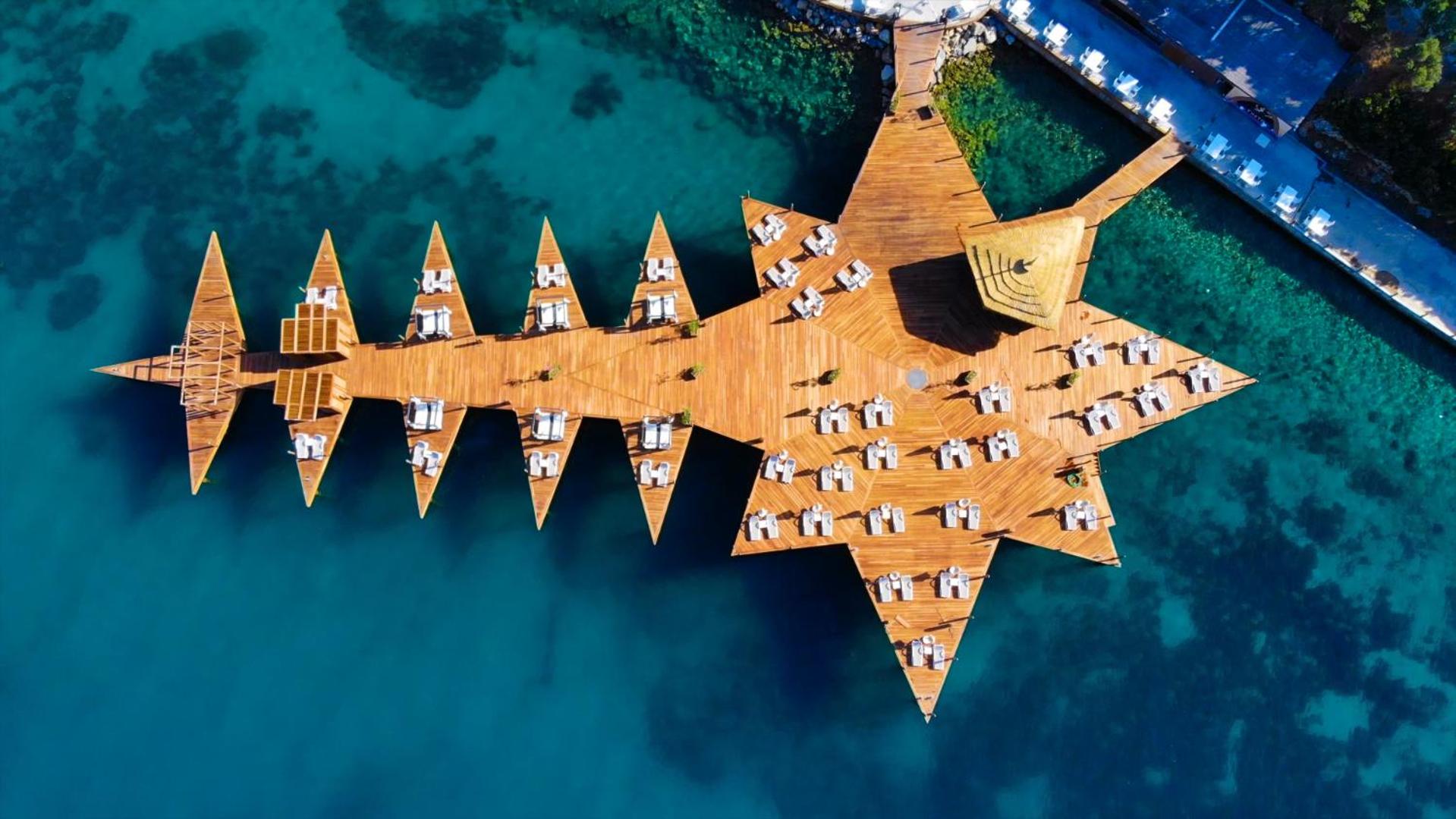 Duja Bodrum unikālā zvaigznes formas koka piestātne no putna lidojuma, izvietota dzidri zilā Egejas jūras ūdenī
