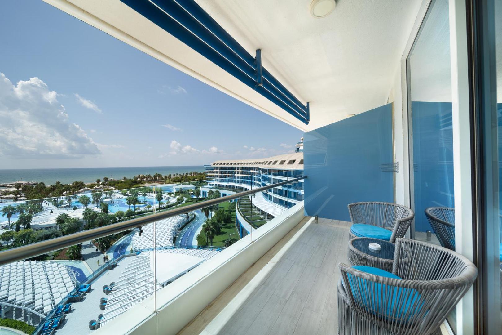 Skats no Sueno Hotels Deluxe Belek balkona uz plašo viesnīcas teritoriju, baseiniem un Vidusjūras piekrasti Belekā