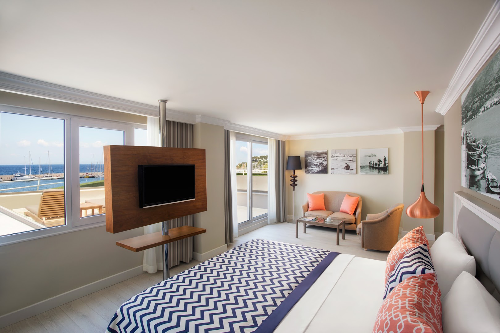 Paloma Marina Suites moderns numurs ar skatu uz jahtu piestātni Kušadasi — gaiša viesistabas zona, liela gulta un panorāmas logi