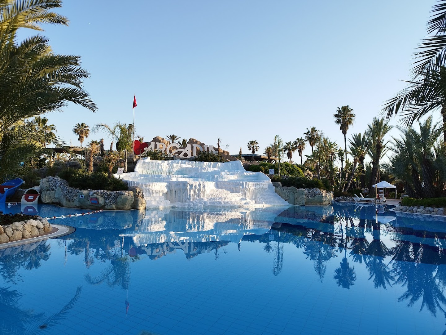 Limak Arcadia Sport Resort dekoratīvās baltās kaskādes pie baseina — arhitektūras elements, kas atgādina Pamukali, Belekas reģionā
