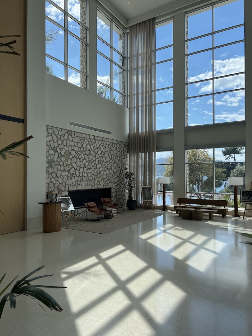 Rixos Premium Bodrum plašais vestibils ar augstiem griestiem, panorāmas logiem un akmens sienas dekoru Bodrumā
