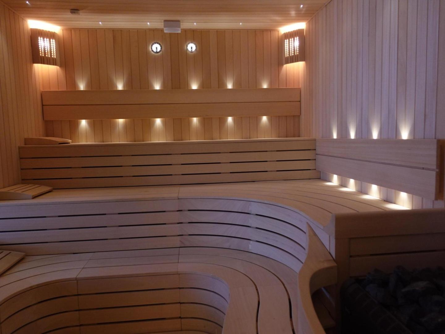 Rixos Premium Bodrum viesnīcas spa centra sauna ar gaiša koka apdari un siltu apgaismojumu Bodrumas reģionā, Turcijā