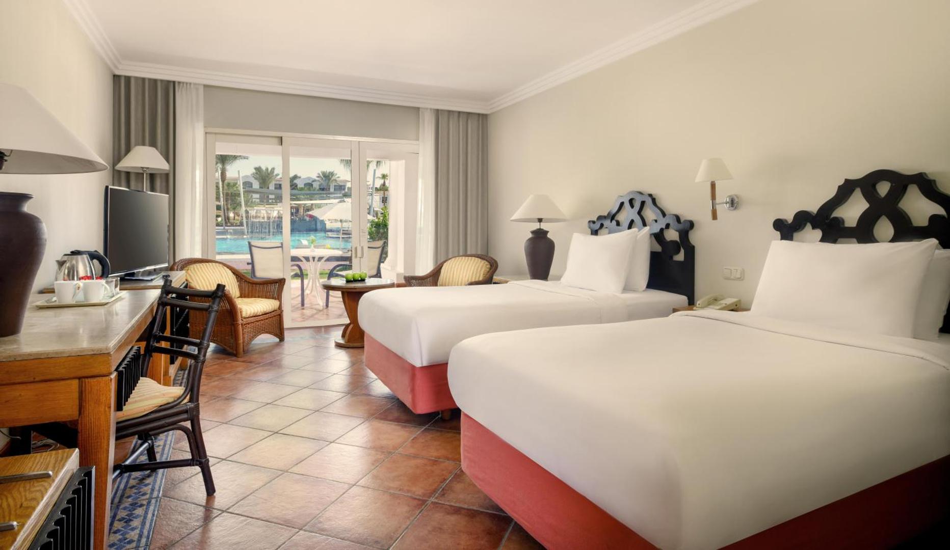 Jaz Sharm Dreams Resort numurs ar divām atsevišķām gultām, flīžu grīdu un izeju uz terasi pie baseina zonas