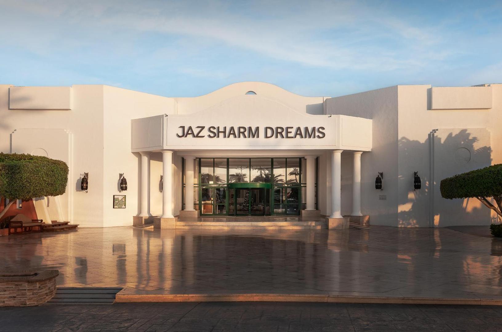 Jaz Sharm Dreams Resort galvenā ieeja Šarm eš Šeihā, Ēģiptē — balta fasāde ar kolonnām un plašu, saules pielietu priekšpagalmu