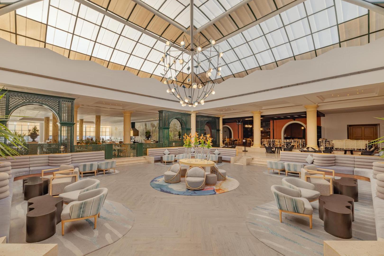 Jaz Sharm Dreams Resort plašais un modernais lobby vestibils ar stikla jumtu, atpūtas zonām un dizaina apgaismojumu Šarm eš Šeihā.