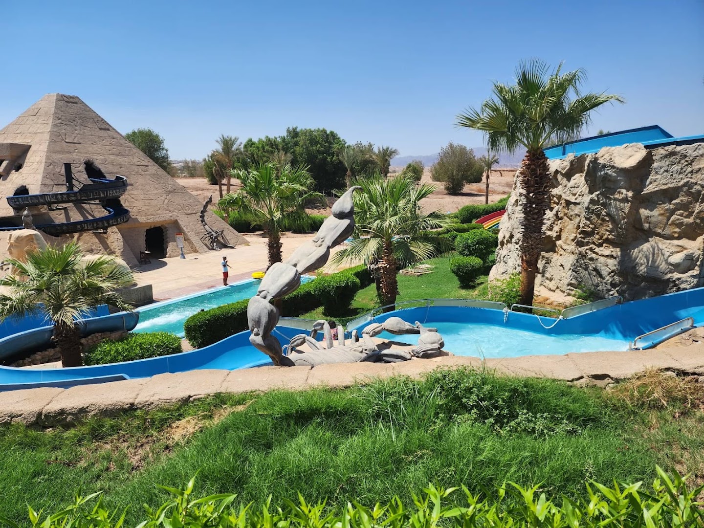 Jaz Sharm Dreams Resort akvaparks ar piramīdas formas slidkalniņu un mākslīgām skulptūrām — plaša ūdens izklaides zona visai ģimenei