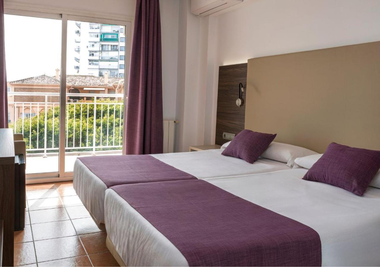 MedPlaya Hotel Alba Beach gaišs numurs ar divguļamo gultu, violetiem akcentiem un balkonu ar skatu uz pilsētu Benalmadenā