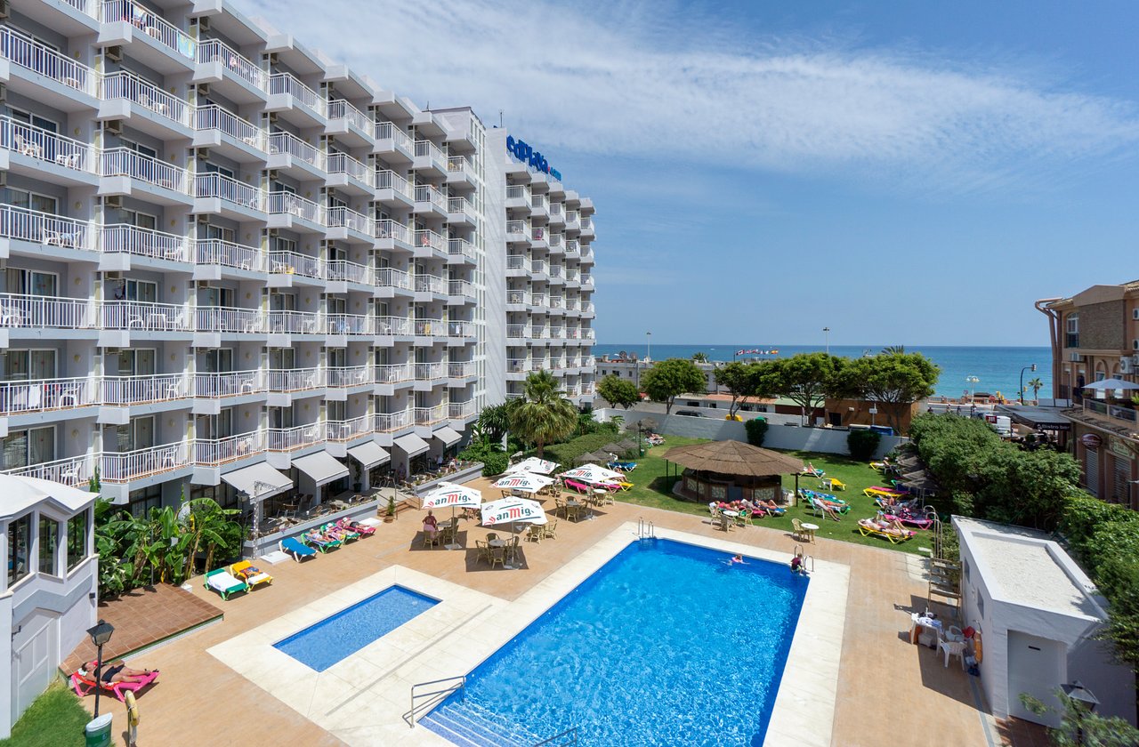 MedPlaya Hotel Alba Beach skats no augšas uz āra baseinu kompleksu un viesnīcas ēku Benalmadenā, Spānijā — sauļošanās zona un jūra fonā