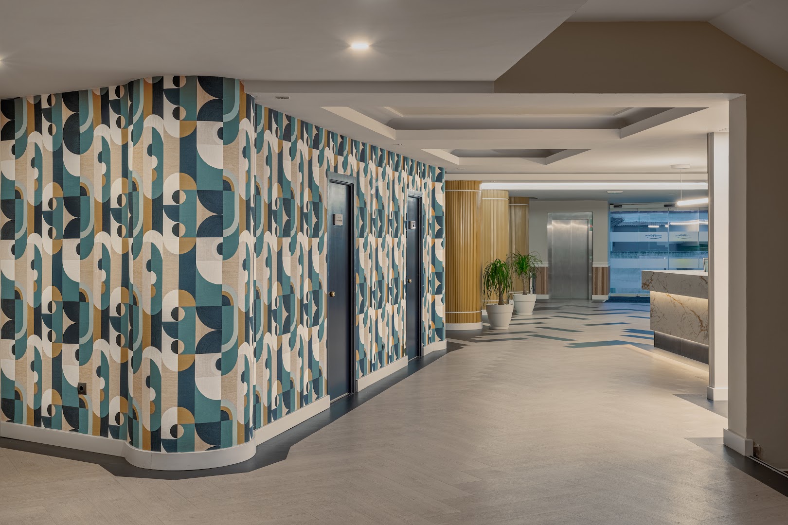 MedPlaya Hotel Alba Beach viesnīcas gaitenis un vestibils ar modernām ģeometriskām tapetēm, liftu un gaišu flīžu grīdu