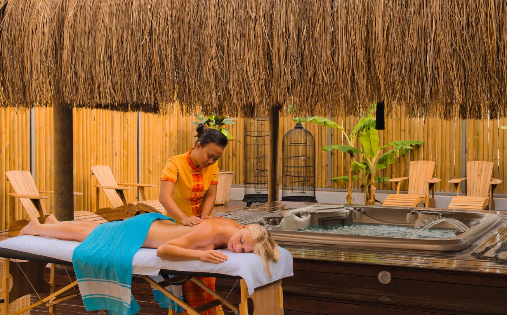 Sentido Bellazure spa zona ar masāžas galdu zem bungalo tipa jumta, blakus džakuzi un atpūtas krēsliem