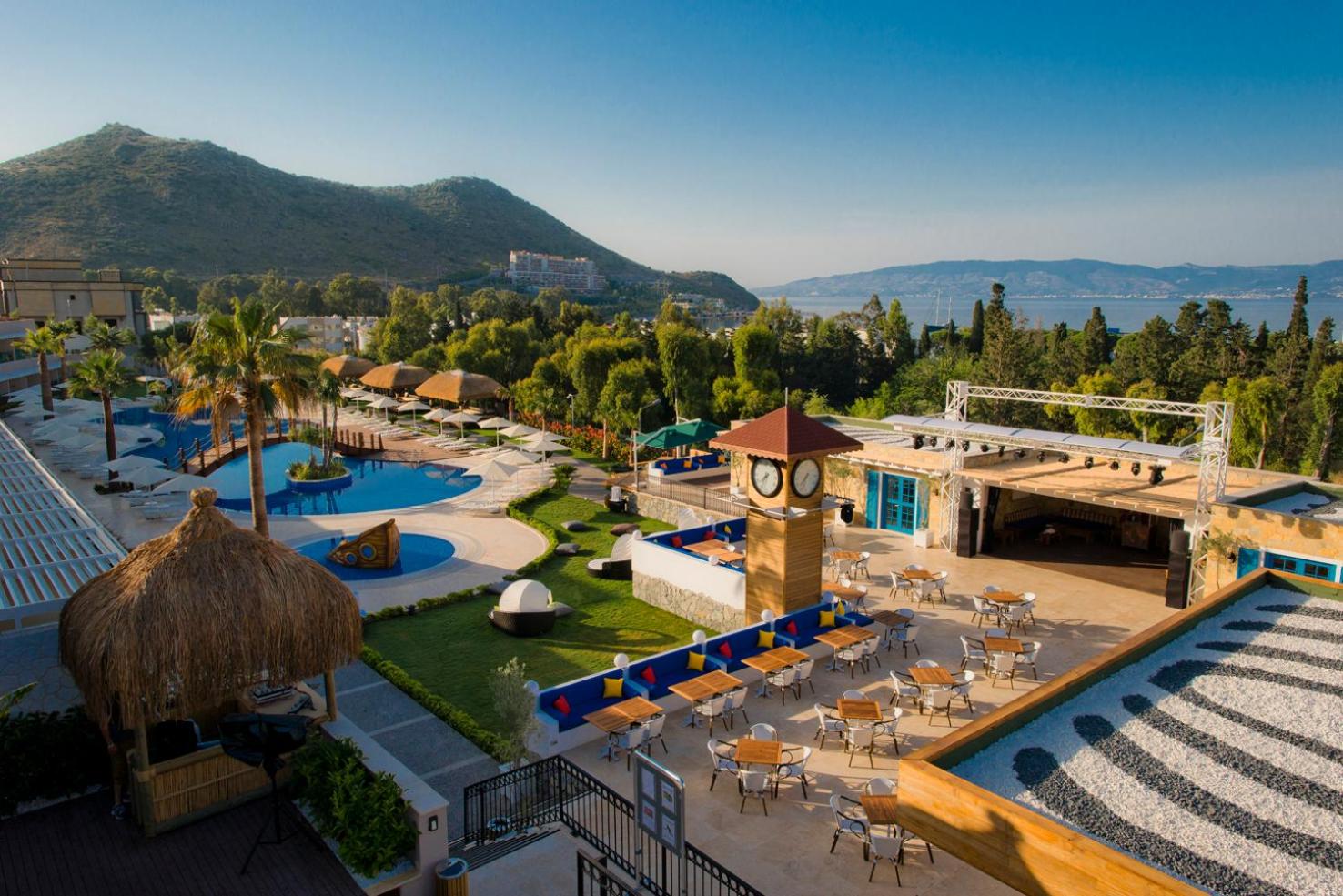 Sentido Bellazure viesnīcas kopskats no augšas ar baseiniem, terasi un kalnu ainavu Bodrumas reģionā, Turcijā saulainā dienā