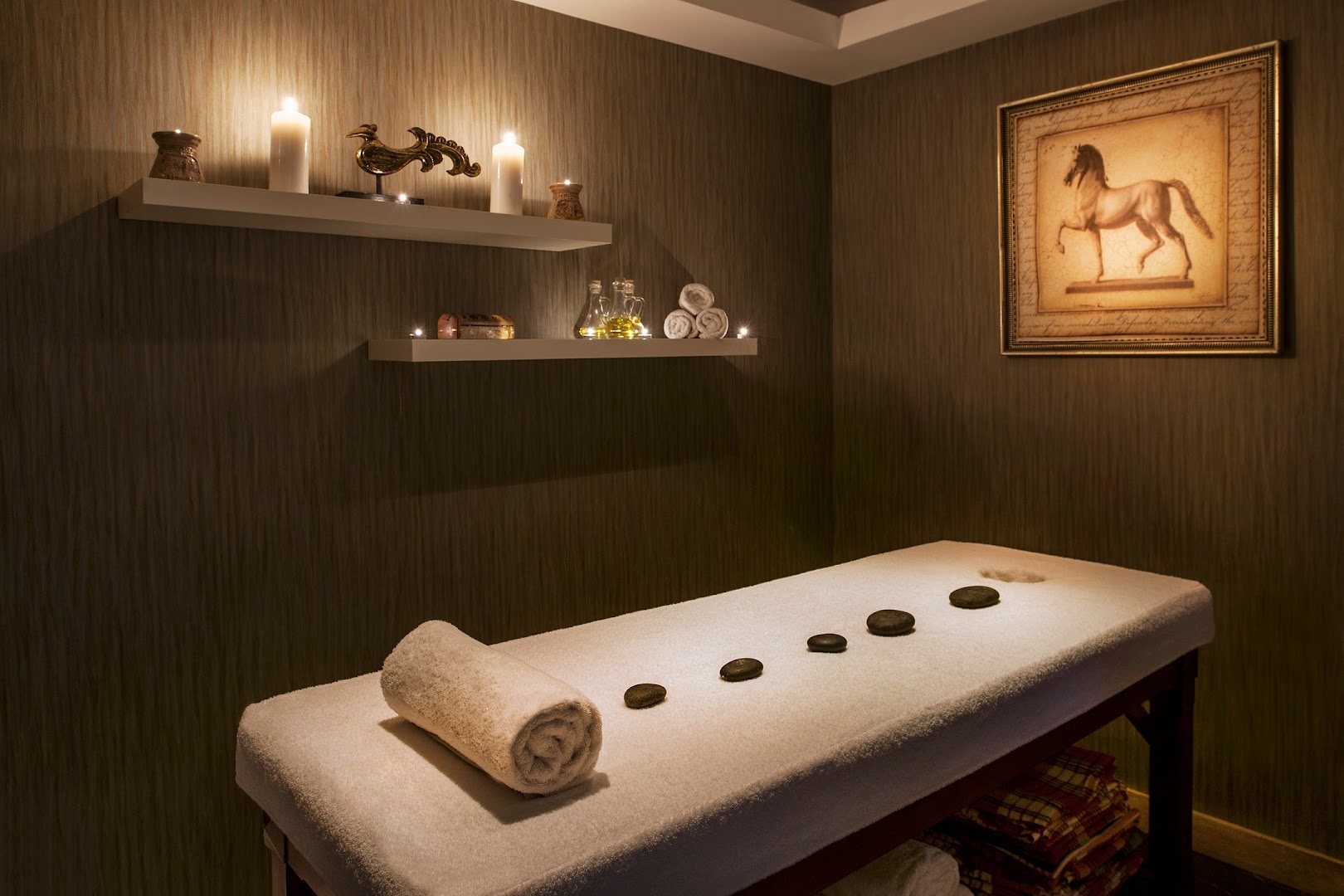 Prive Hotel Bodrum spa procedūru telpa ar masāžas galdu, svecēm, akmeņiem un nomierinošu apgaismojumu