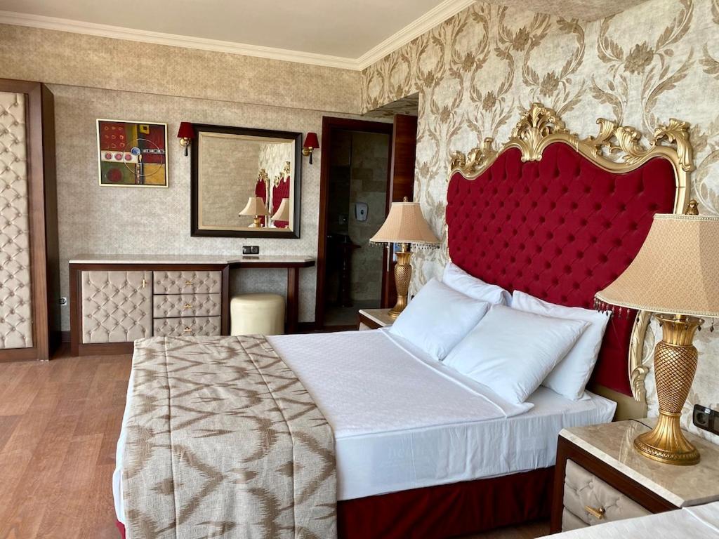 LAUR HOTELS Experience & Elegance luksusa numurs ar sarkanu samta galvgali, zeltītiem elementiem, tualetes galdiņu un spoguli