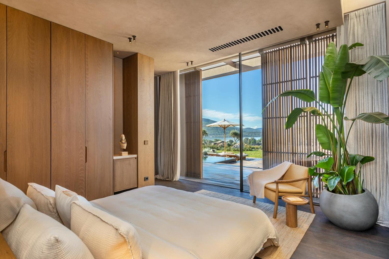 Lujo Hotel Bodrum guļamistaba ar skatu uz jūru, privāto baseinu un terasi caur lieliem panorāmas logiem