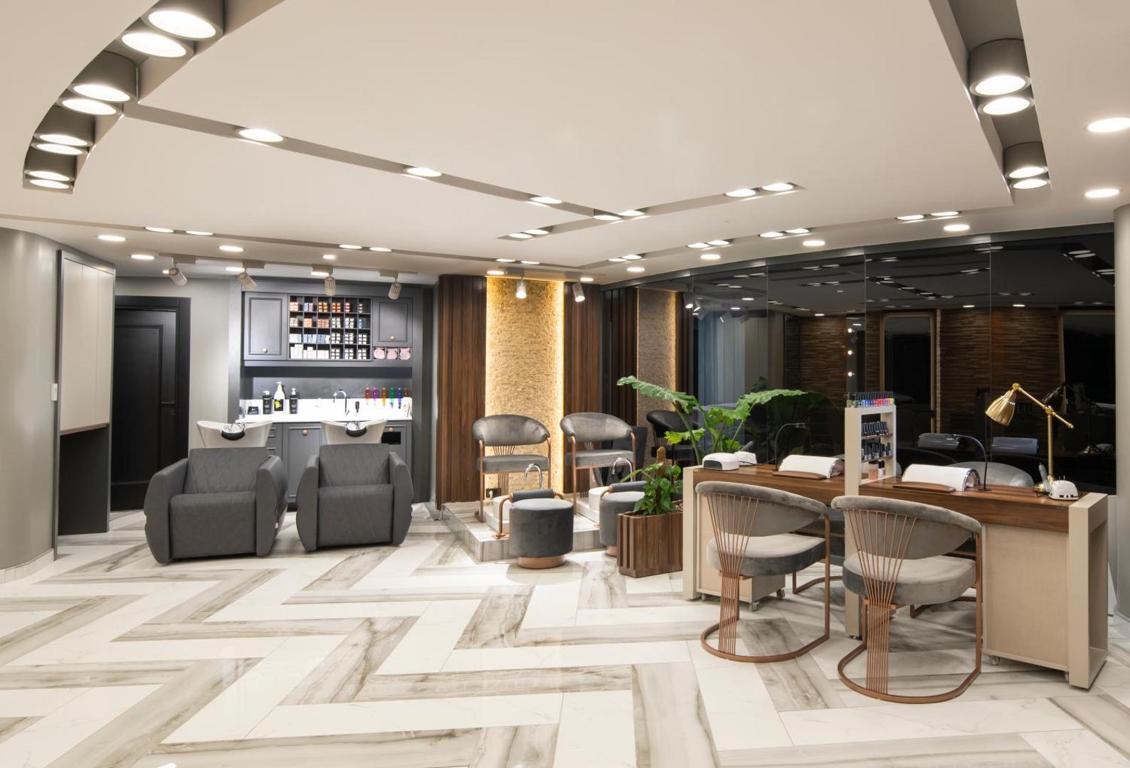 Lujo Hotel Bodrum skaistumkopšanas salons un spa zona ar manikīra galdiem un frizētavas aprīkojumu gaišās telpās.