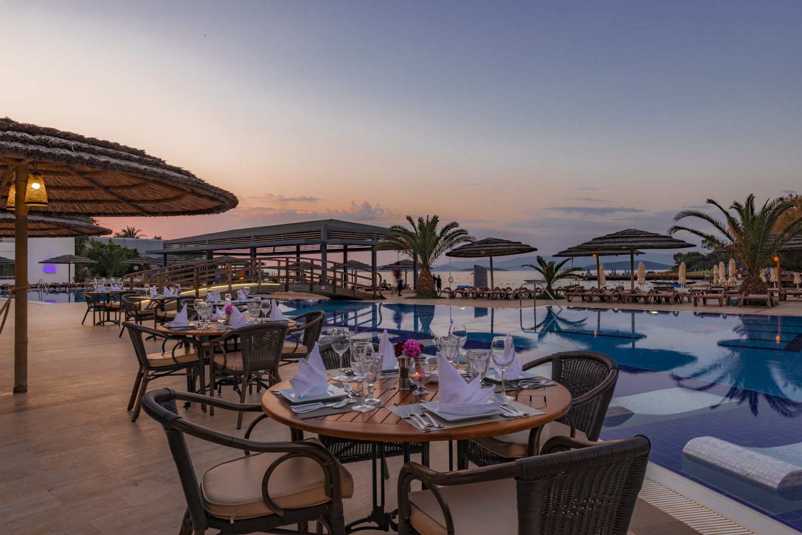 Samara Hotel Bodrum restorāna terase saulrietā pie baseina ar skatu uz jūru un kalniem Bodrumas piekrastē