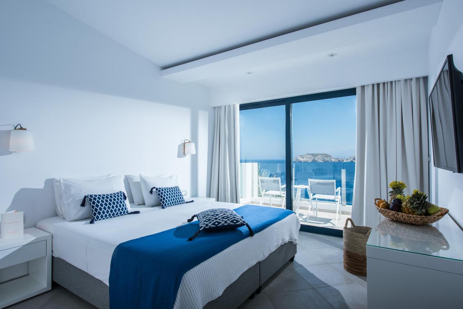 Peninsula Resort & Spa gaišs numurs ar skatu uz jūru Agia Pelagia, Krētā — divguļamā gulta ar ziliem akcentiem un balkons