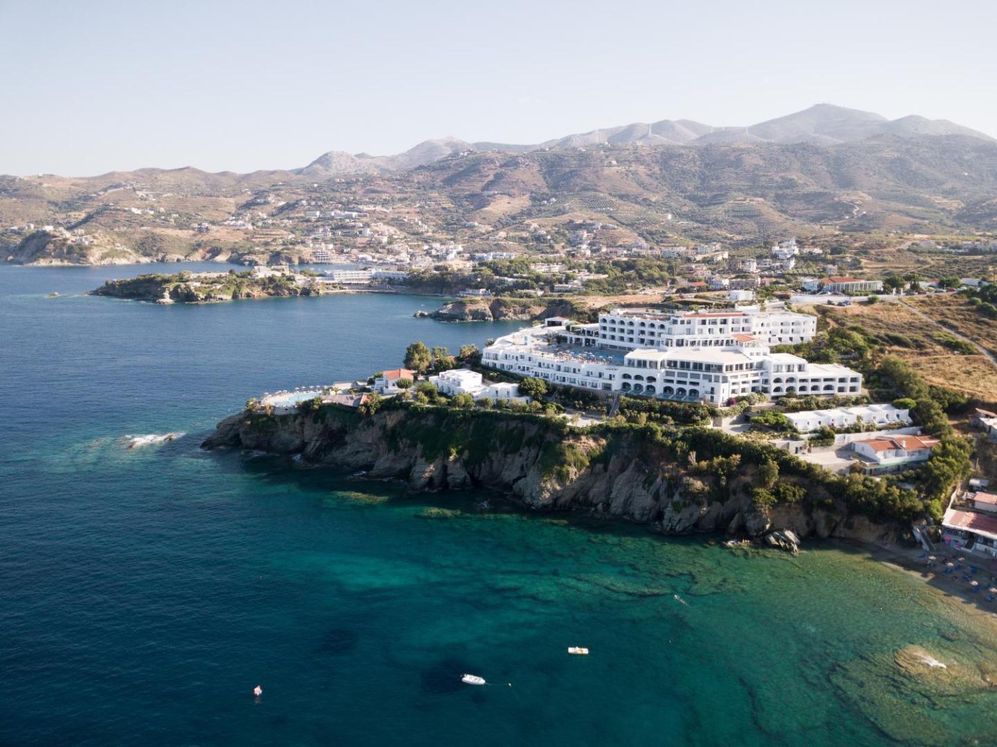 Peninsula Resort & Spa panorāmas skats no putna lidojuma uz Agia Pelagia piekrasti Krētā ar zilu jūru un kalniem