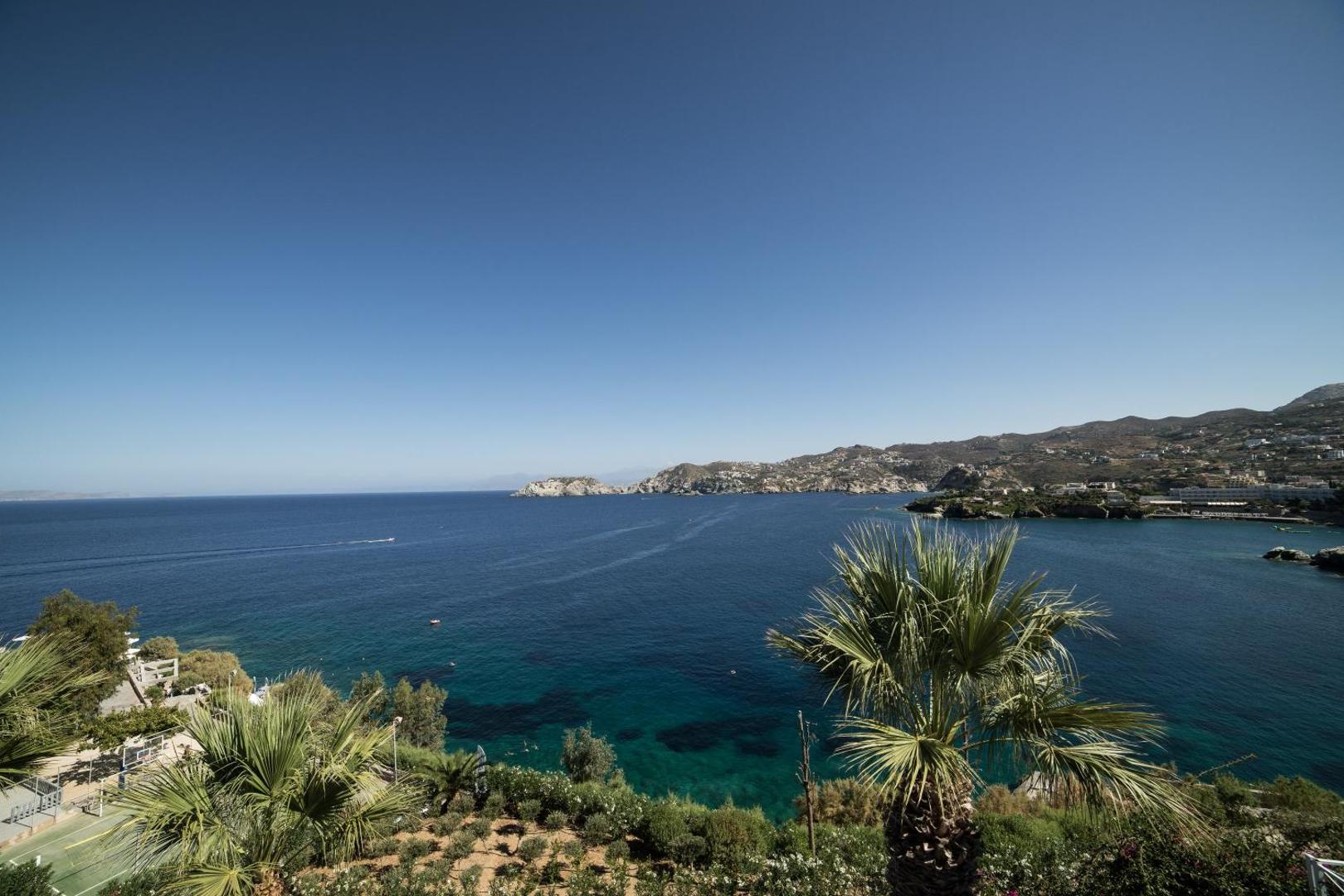 Panorāmas skats no Peninsula Resort & Spa terases uz Agia Pelagia līci, apkārtējiem kalniem un kūrorta zaļo teritoriju.