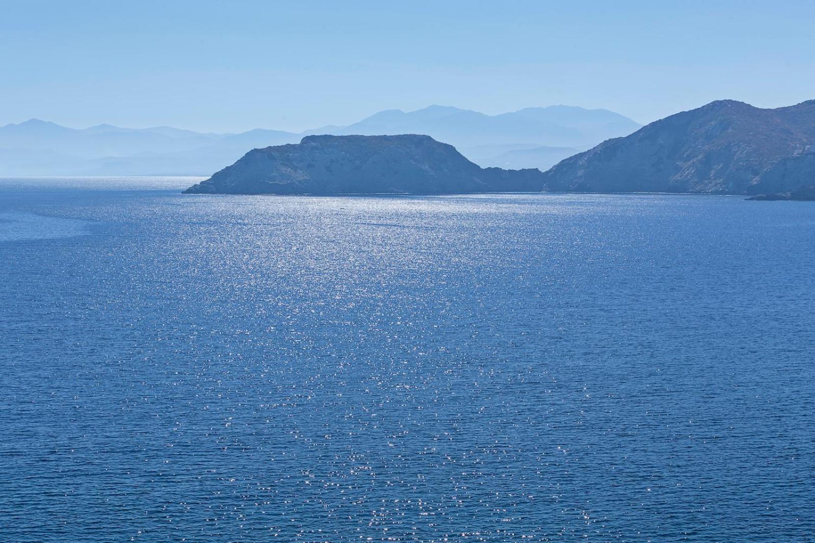 Peninsula Resort & Spa skats uz mirdzošo Vidusjūru un kalnaino piekrasti Agia Pelagia reģionā, Krētā saulainā dienā.