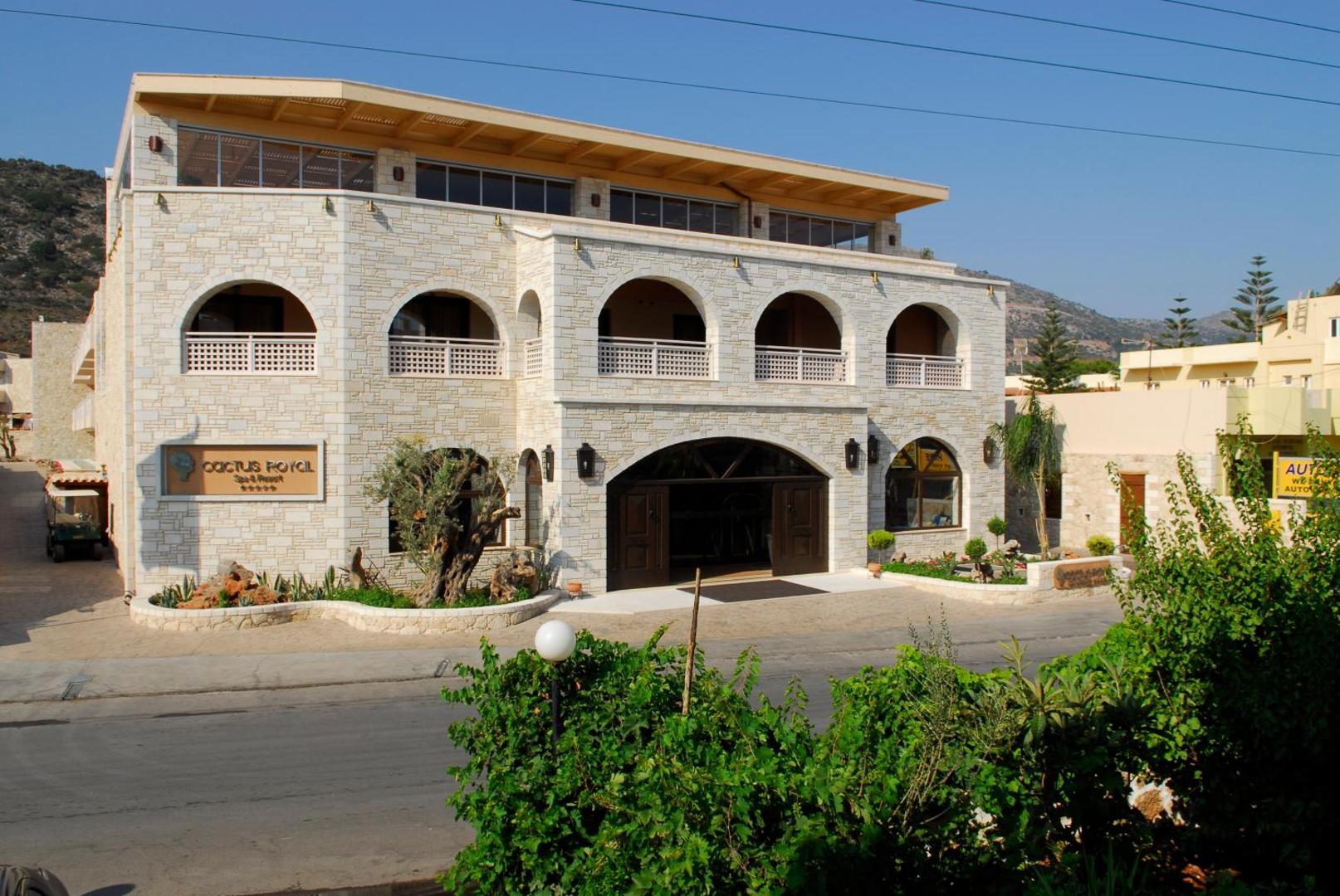 Viesnīcas Cactus Royal Spa & Resort fasāde ar akmens arkām un balkoniem.
