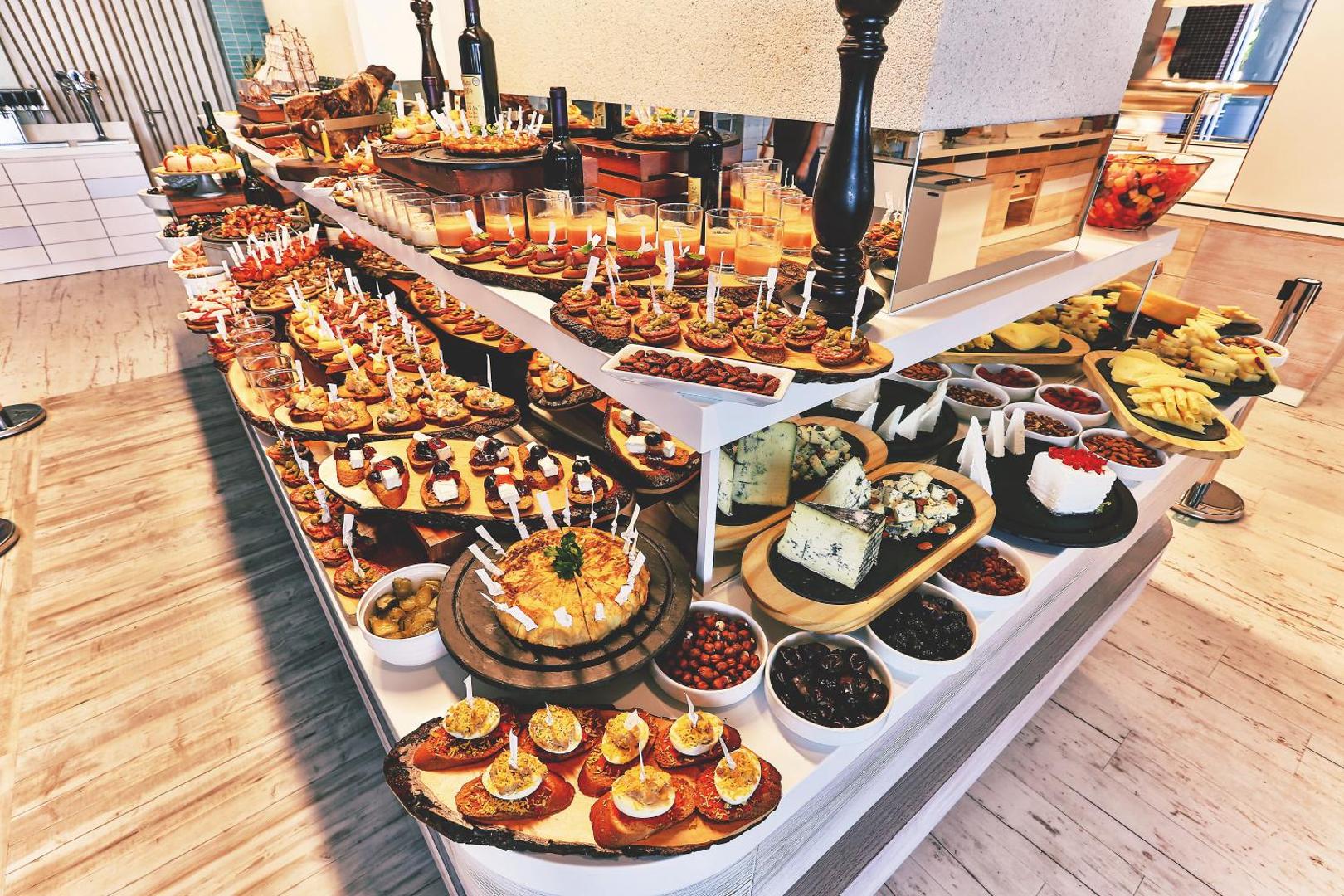 Uzkodu galds Carine Hotel Park restorānā ar dažādām maizītēm, sieriem, olīvām un tradicionālām Vidusjūras uzkodām