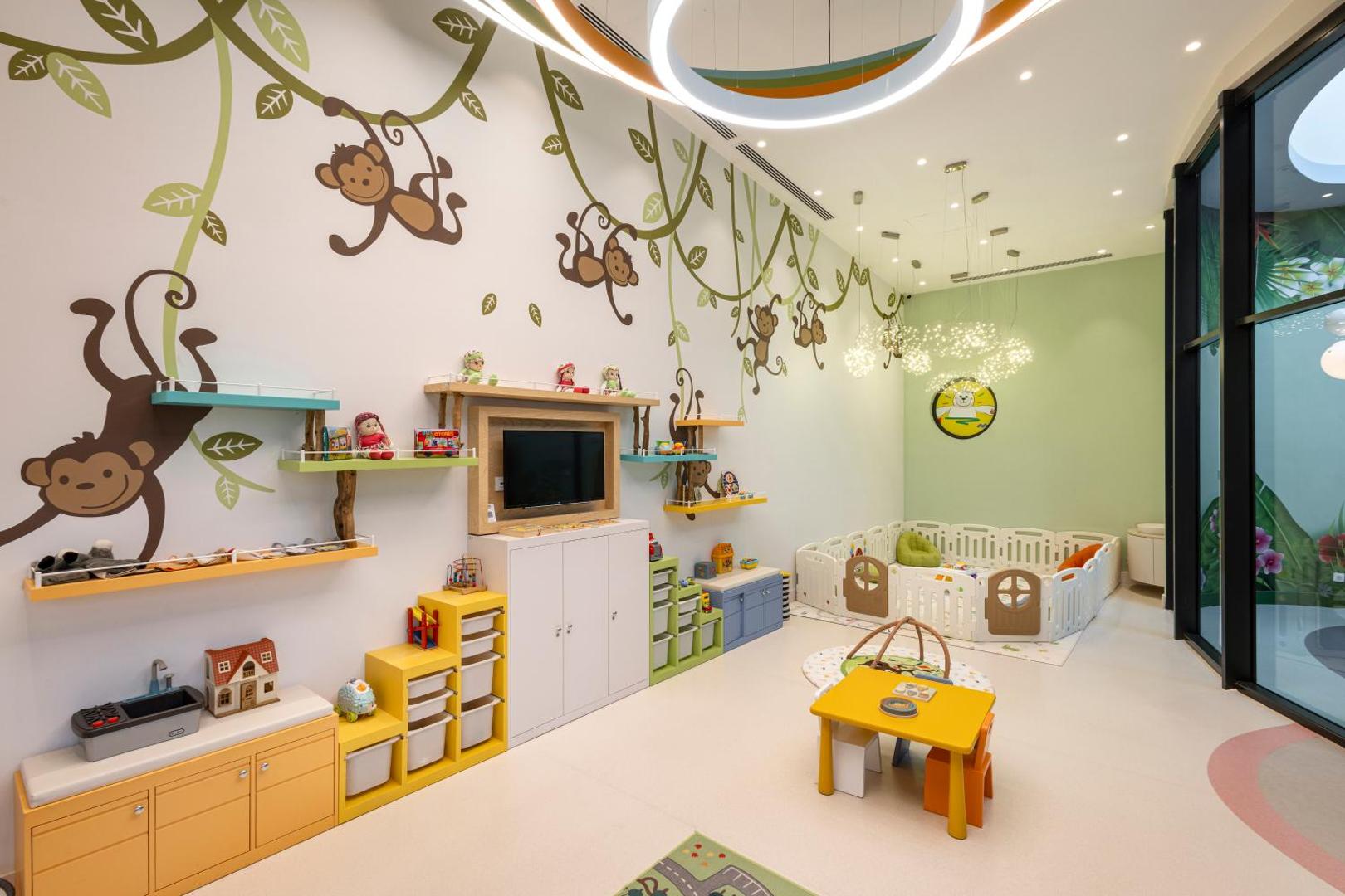 Ela Excellence Resort Belek rotaļu istaba ar pērtiķu zīmējumiem uz sienām, rotaļlietām un drošu zonu mazuļiem — bērnu kluba iekštelpas