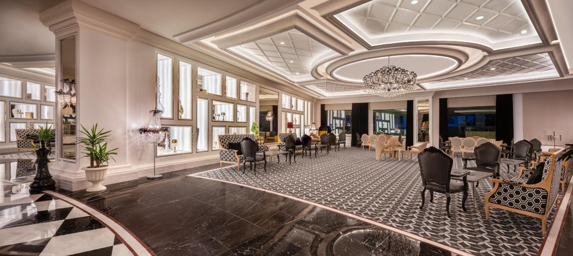 Delphin Imperial Hotel greznais lobby atpūtas salons ar klasiskām mēbelēm, kristāla lustrām un melnbaltu marmora grīdu