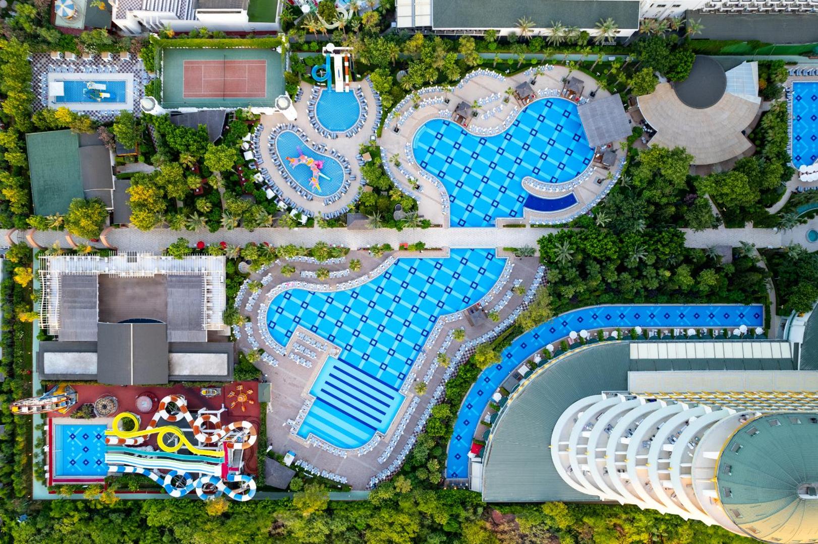 Delphin Imperial Hotel teritorijas skats no putna lidojuma — baseini, akvaparks, tenisa korts un dārzi