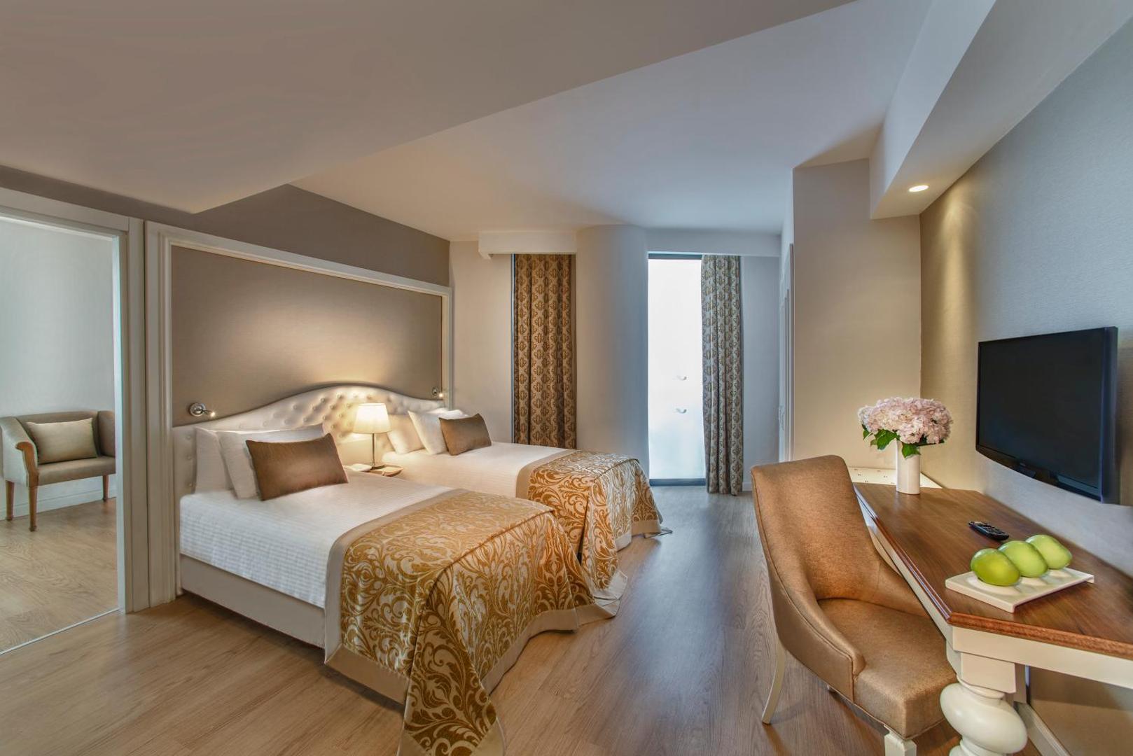 Aska Lara Resort & Spa ģimenes numurs ar divām atsevišķām gultām, gaišām mēbelēm un atsevišķu ieeju blakus telpā.