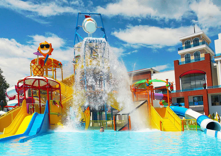 Club Aqua Plaza bērnu ūdens atrakciju parks ar krāsainiem slidkalniņiem un ūdens spaini, kas gāžas pāri baseinam