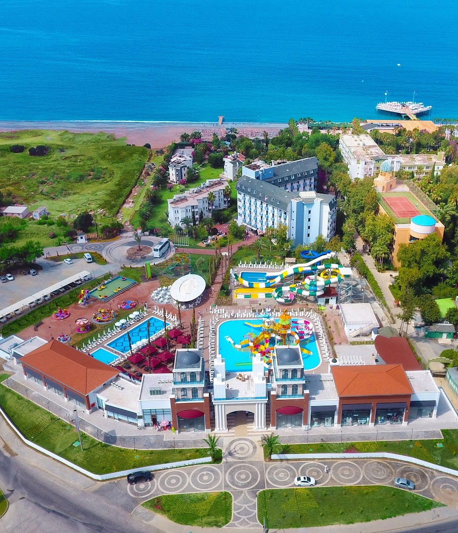 Club Aqua Plaza viesnīcas teritorija no putna lidojuma Alānijā, Turcijā — redzami baseini, ūdens slidkalniņi, ēkas un pieeja jūras krastam