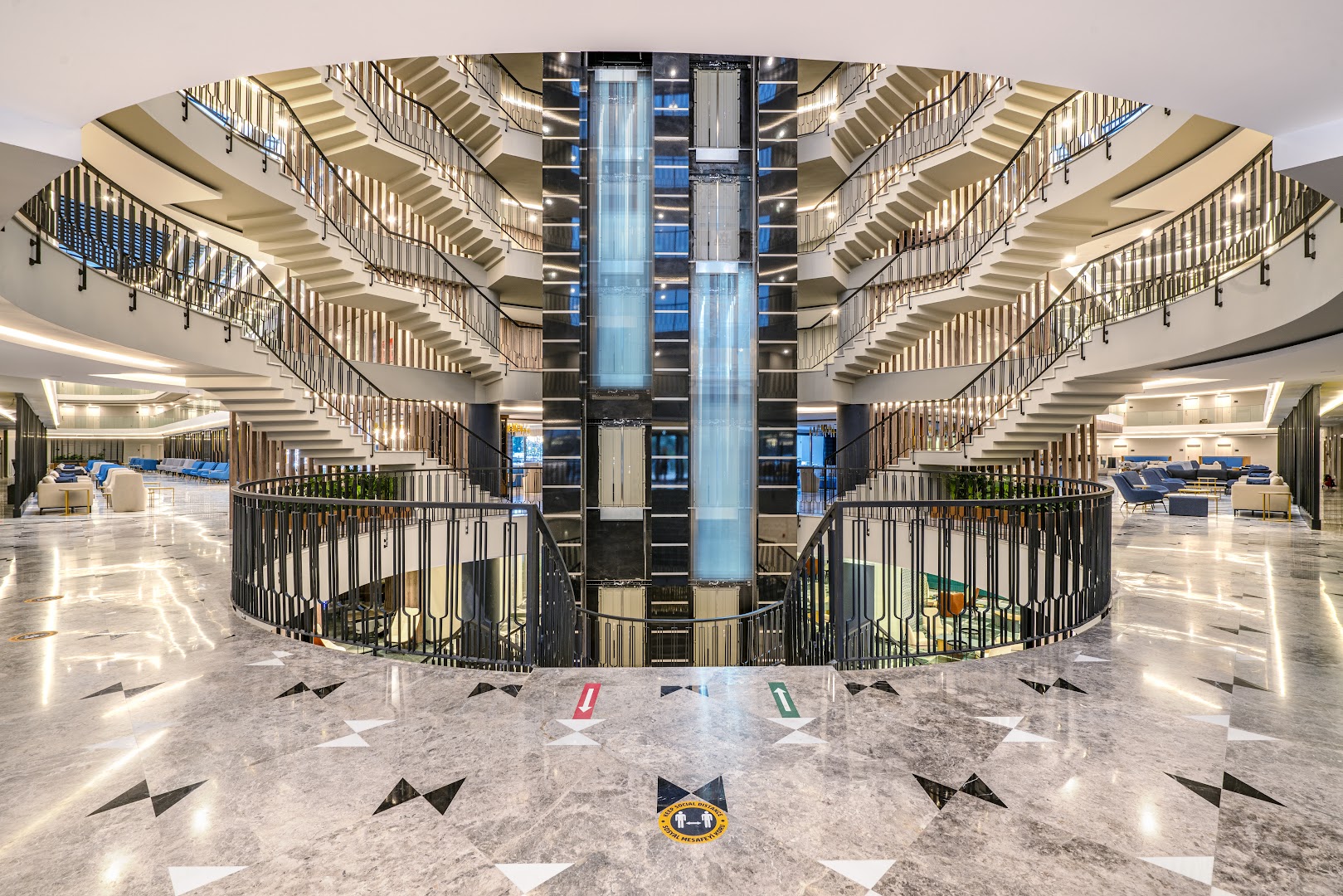 Arnor De Luxe Hotel & Spa centrālais vestibils ar stikla liftiem, simetriskām kāpnēm un marmora grīdu Sidā, Turcijā