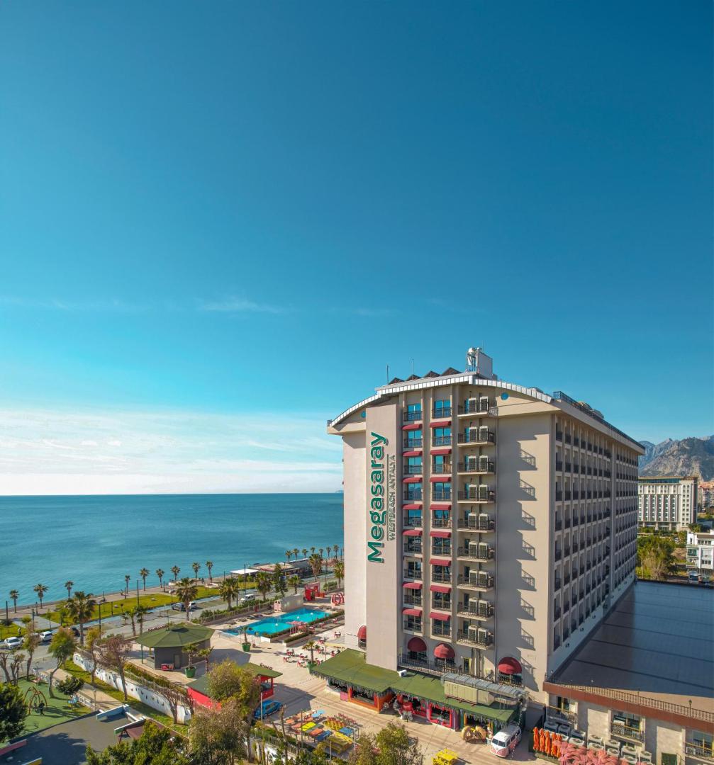 Skats no augšas uz Megasaray Westbeach Antalya viesnīcu, Vidusjūras piekrasti un pilsētas panorāmu saulainā dienā.