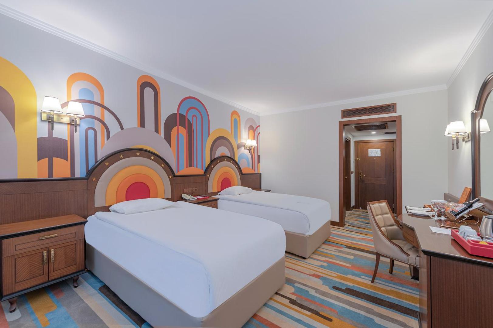 Megasaray Westbeach Antalya viesnīcas divvietīgs numurs ar modernu interjeru, divām atsevišķām gultām un dekoratīvu sienas apdari