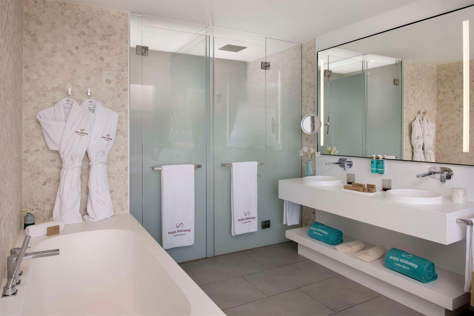 Royal Hideaway Corales Suites plaša vannas numura interjers ar vannu, dušu un dubulto izlietni — gaišs un mūsdienīgs dizains