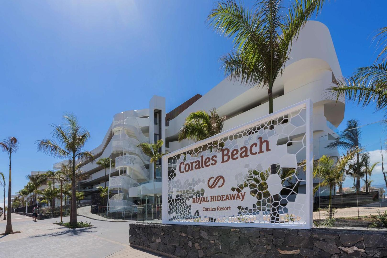 Royal Hideaway Corales Beach ieejas zīme pie kūrorta Tenerifē — moderna fasāde ar palmām un gājēju celiņu