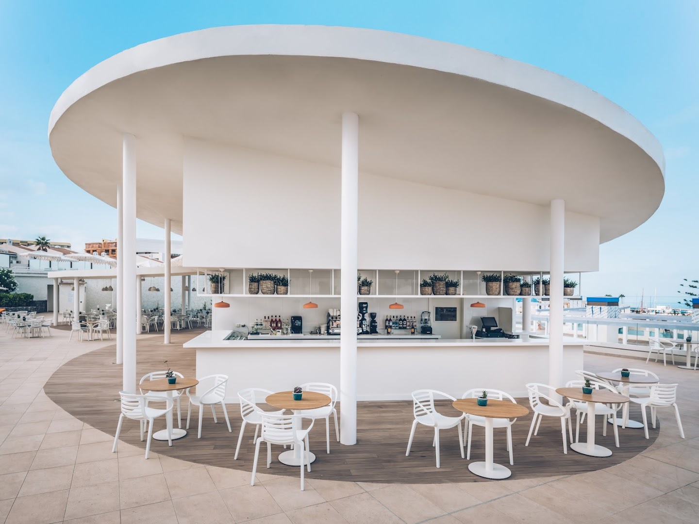 Iberostar Sabila viesnīcas baseina bāra zona ar baltiem krēsliem un koka galdiņiem gaišā, modernā stilā