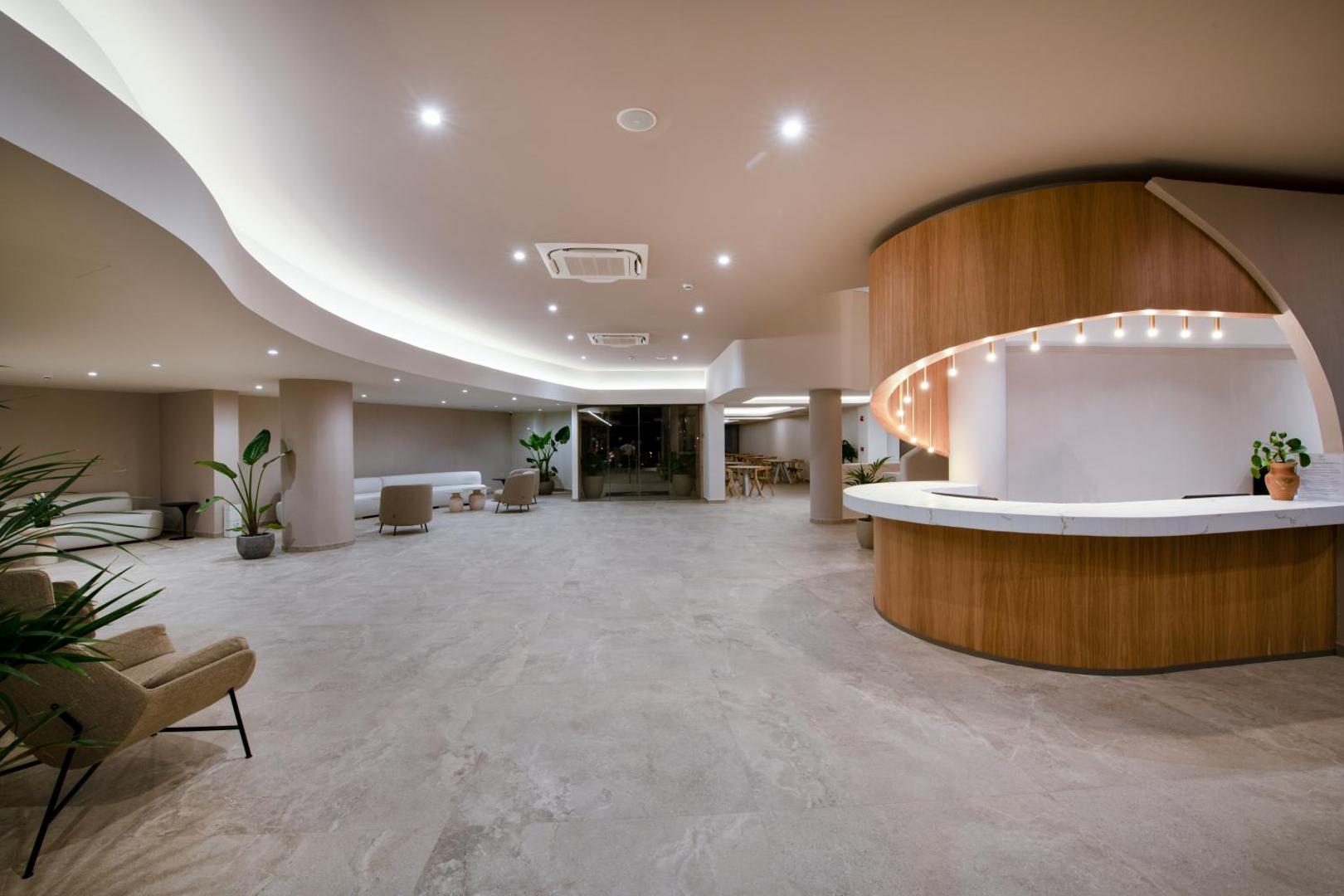 Ventale Island Breeze Resort plašā lobby zona ar modernu reģistratūras leti un atpūtas dīvāniem