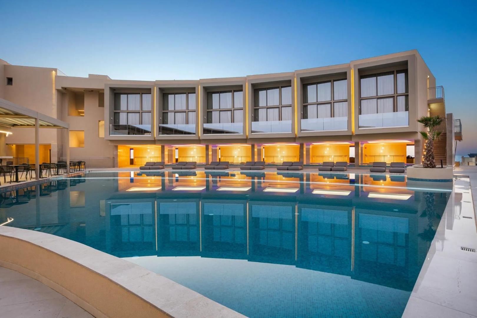 Ventale Island Breeze Resort viesnīcas fasāde un plašais baseins krēslas stundā — moderni numuri ar stikla balkoniem un atpūtas zonu.