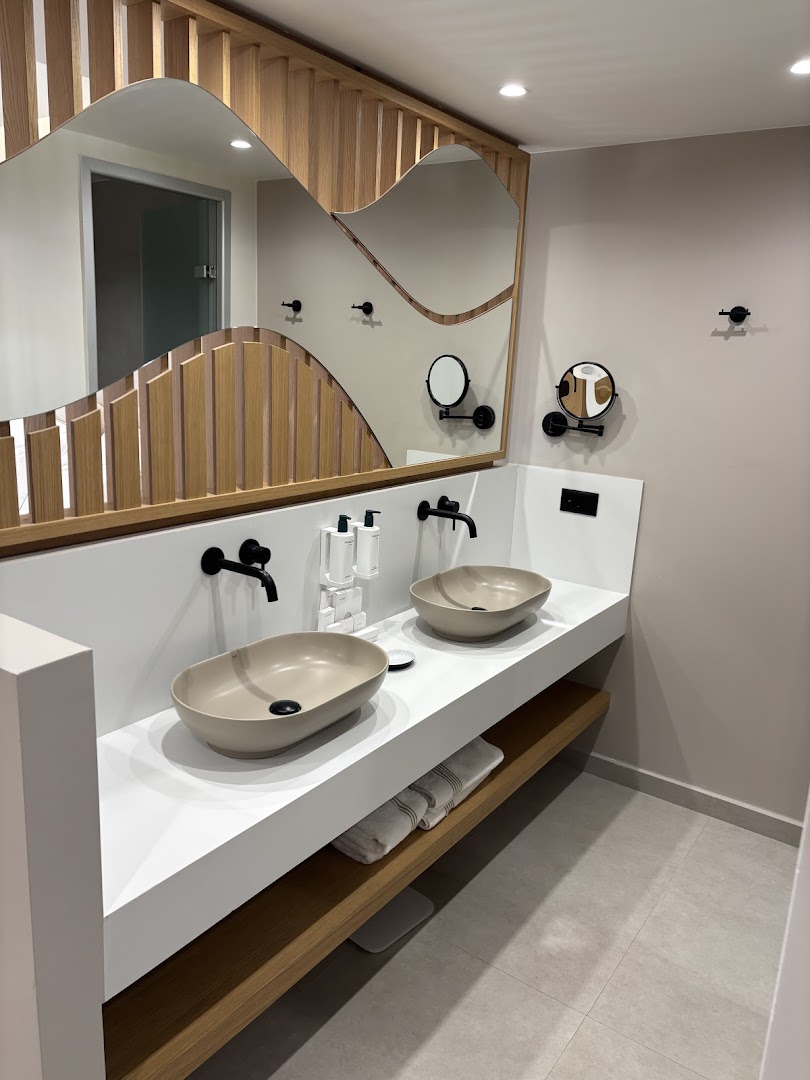 Ventale Island Breeze Resort moderna vannas istaba ar divām izlietnēm, dizaina spoguli un koka apdares elementiem gaišos toņos.