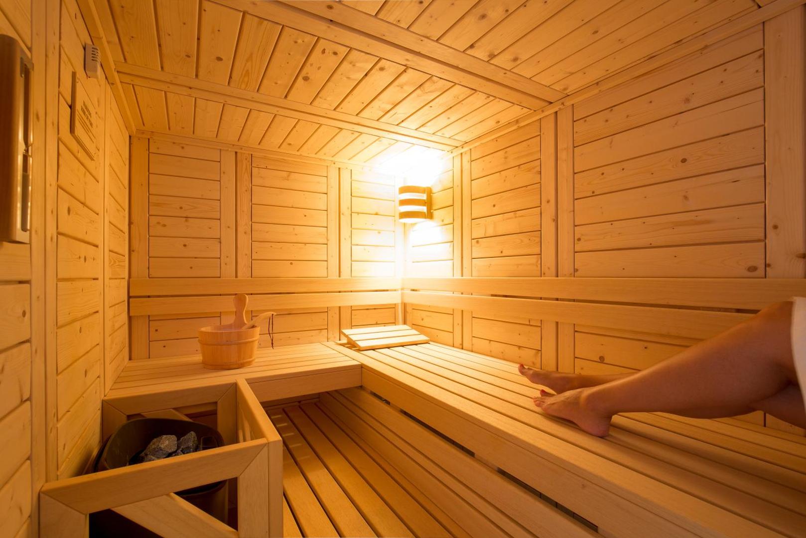 Rodostamo Hotel & Spa tradicionālā koka sauna ar siltu apgaismojumu un ērtiem soliem viesu labsajūtai