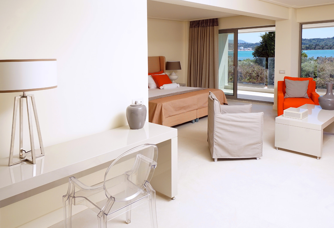 Rodostamo Hotel & Spa moderns un gaišs numurs ar lielu gultu, atpūtas zonu un skatu uz jūru caur logu