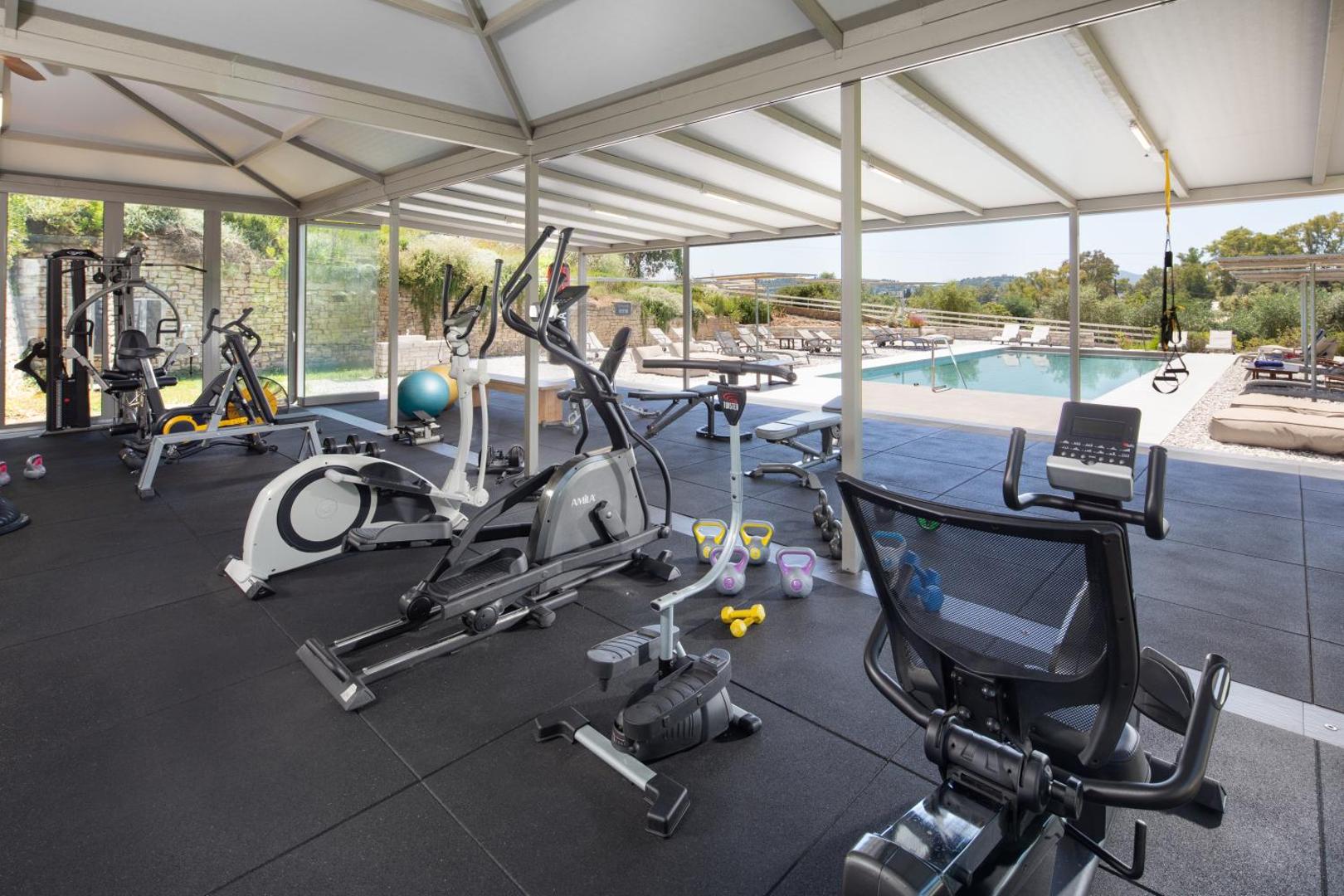 Rodostamo Hotel & Spa fitness centrs ar skatu uz āra baseinu un kalniem Korfu salā, Grieķijā