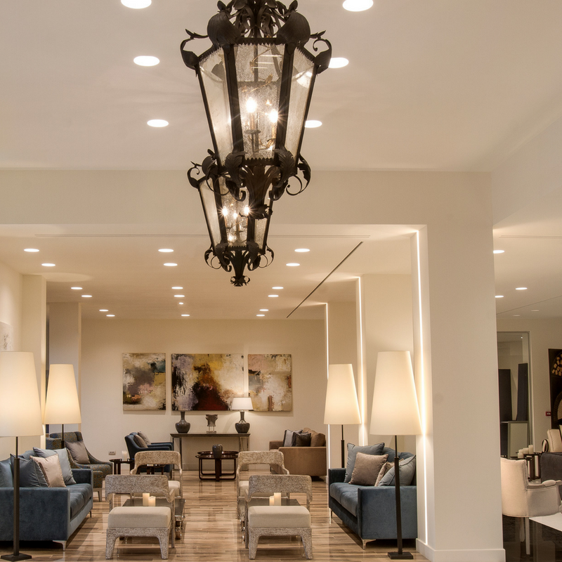 Rodostamo Hotel & Spa elegantā lobby atpūtas zona Korfu salā ar moderniem dīvāniem, mākslas darbiem pie sienām un greznām lustrām