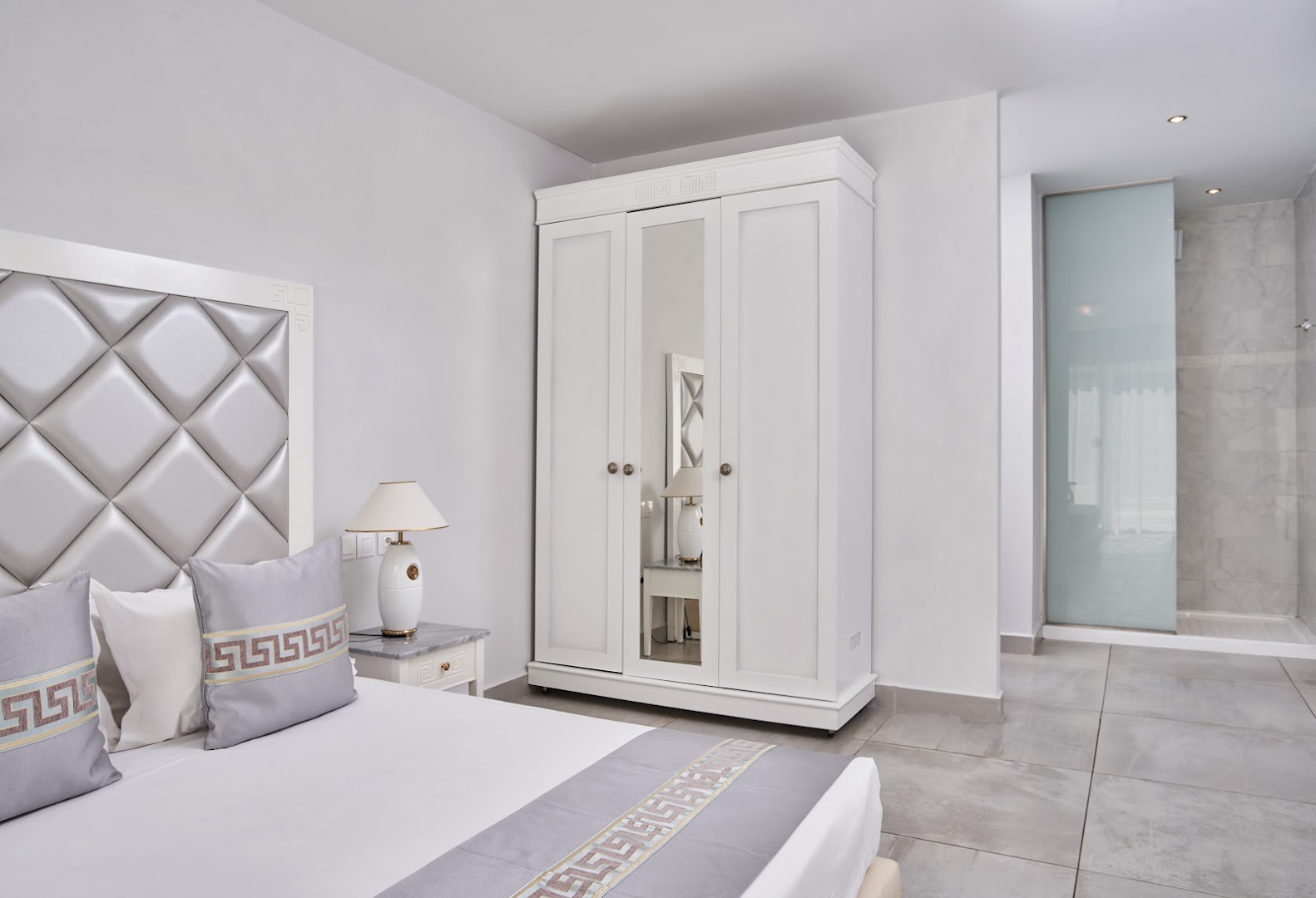 Sandy Villas Resort gaišs numurs ar lielu skapi, spoguli un mīkstu galvgali — moderna guļamistaba ar ieeju dušas zonā