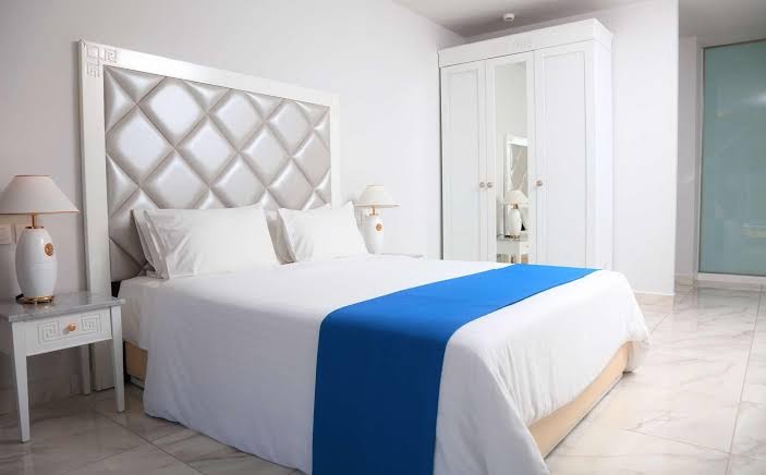 Sandy Villas Resort numurs ar divguļamo gultu, baltu gultas veļu un zilu dekoratīvo elementu — klasisks dizains ar marmora grīdu